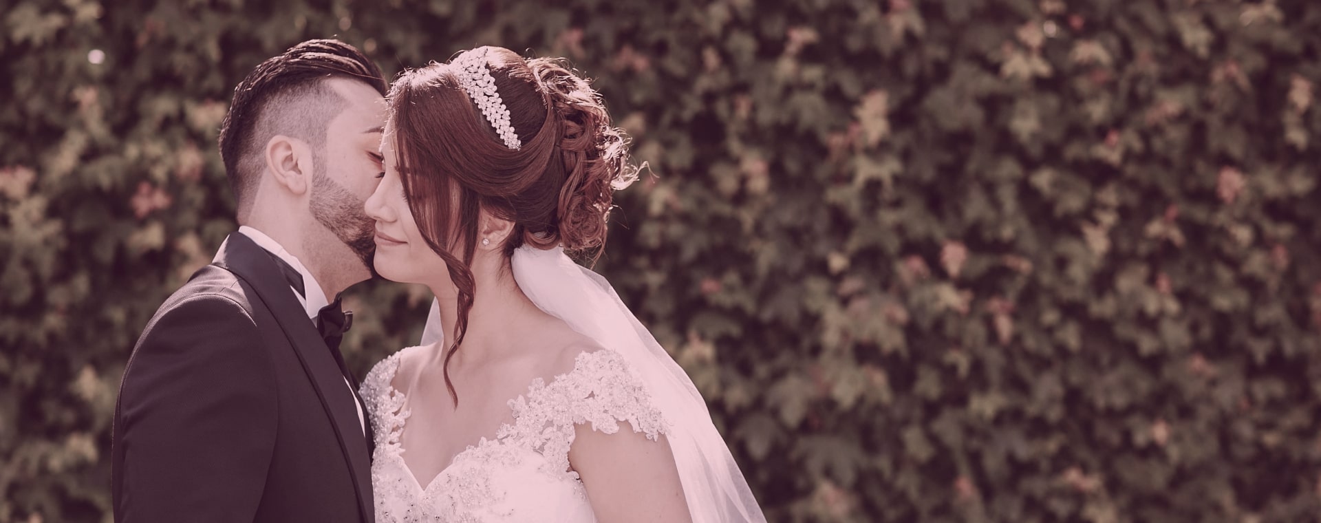 Couple turcs vêtus d'habits de mariage &#58; l'époux embrasse sa femme en robe de mariée sur la joue